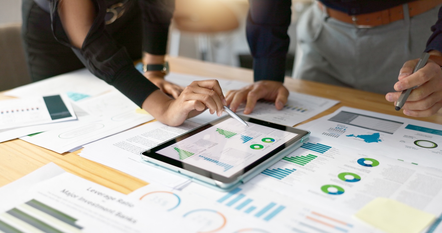 Business people, data analysis with tablet and paperwork, hands with online review in meeting and team with market research. Statistics, analytics dashboard and digital infographic with collaboration.